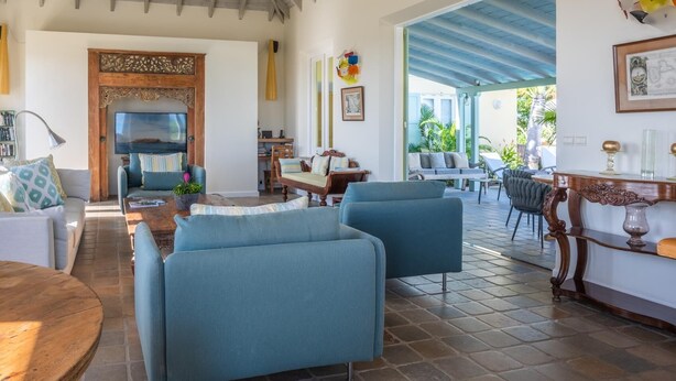 A spacious living area with a wooden ceiling, a large wooden cabinet, and a view of the outdoors. - Armor (1/3 Rooms) Luxury villa (Pointe Milou - Montjean)