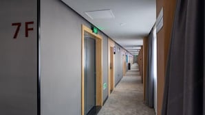 A hotel corridor with doors marked with room numbers, a carpeted floor, and a wooden wall panel. - Thank U Hotel (Lengshuijiang Red Double Happiness Building Material Market) (Lengshuijiang)