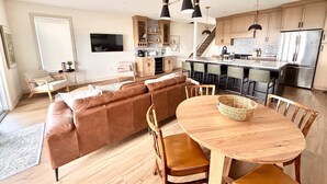 Une cuisine moderne dotée d’un îlot central, de meubles en bois et d’appareils électroménagers en acier inoxydable.