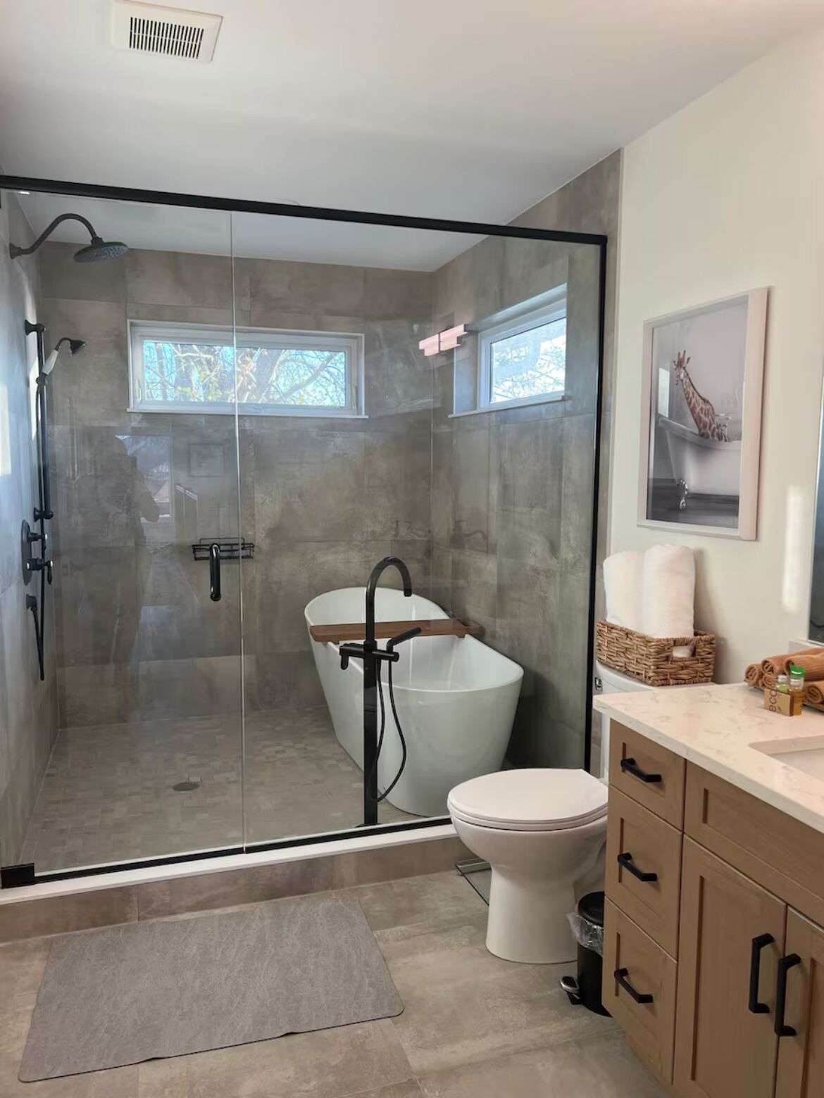 A modern bathroom with a glass-enclosed shower, a freestanding bathtub, a toilet, and a vanity with a sink.