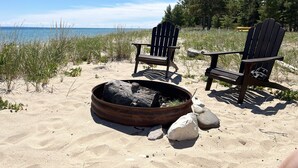 A beach scene with two Adirondack chairs and a fire pit. - Lake Michigan/Beaver Island with incredible private beach (Beaver Island)