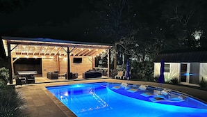 An outdoor pool area with a covered seating area and a wooden structure. - Coastal Cottage in Charming Old Mt Pleasant! (Mount Pleasant)