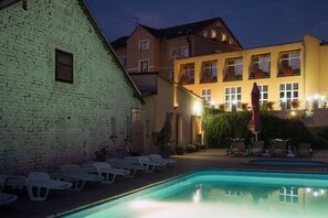 Een seizoensgebonden buitenzwembad en parasols bij het zwembad