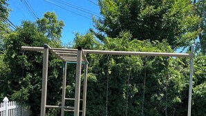 Une aire de jeux avec des balançoires et une structure d’escalade.