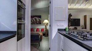 Eine moderne Küche mit Einbauofen und Essbereich mit Sofa und Tisch.