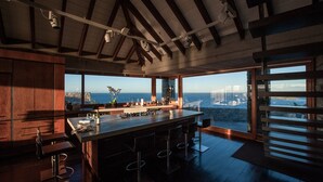 A modern kitchen with a large island, bar seating, and a view of the ocean.