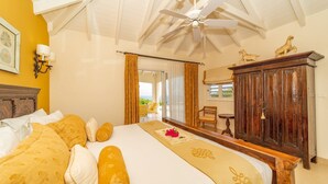 A bedroom with a large bed, a wooden wardrobe, a ceiling fan, and a view of the outdoors. - Maracuja (1/3 Rooms) Luxury villa (Vitet)