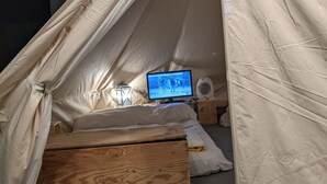 A tent with a bed, a television, and a fan. - camping san javier (San Javier)