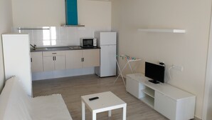 A compact kitchen with a microwave, refrigerator, and a small table. - camping san javier (San Javier)