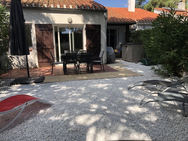 Ein Patio mit Tisch und Stühlen, umgeben von weißen Kieselsteinen.