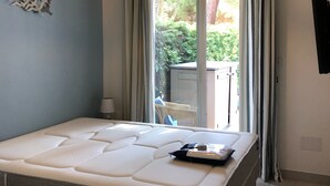 Un dormitorio con una cama grande, un ventilador de techo y vistas al exterior.