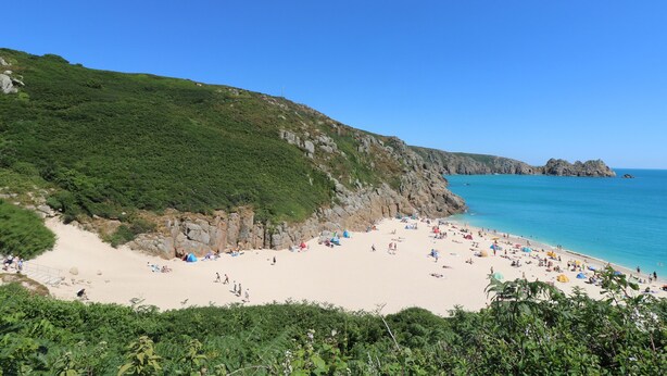 A beach with rocky cliffs and a clear blue sky. - Chynance (Penzance)