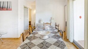 A dining area with a checkered tablecloth, a central white bowl, and two decorative vases. - Apartment on the Paseo Marítimo '1-3' close to the Beach with Terrace & Wi-Fi (Llançà)