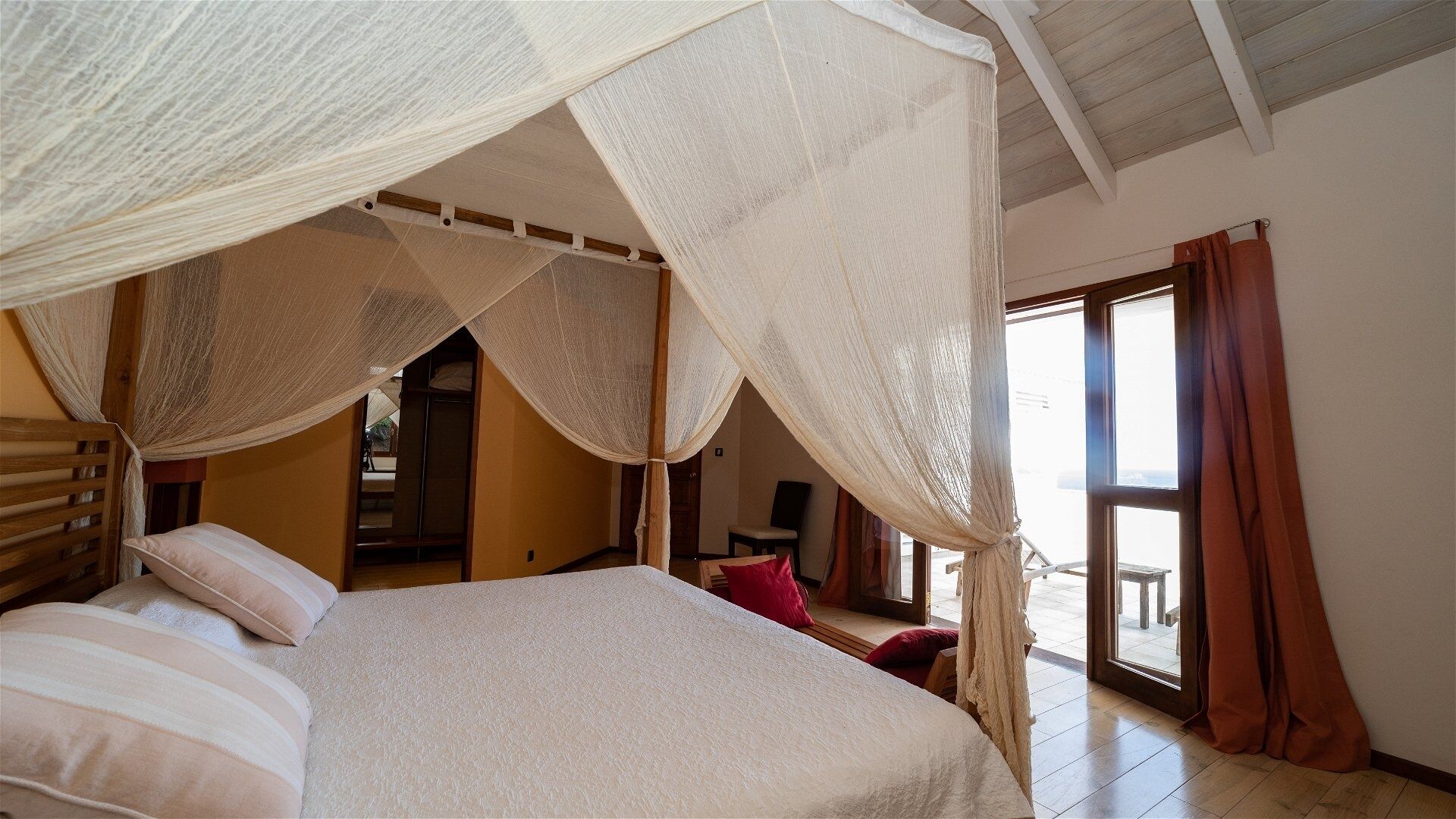 Une chambre à coucher avec un lit à baldaquin, une tête de lit en bois et un dais.