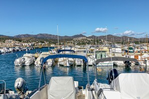 A marina with boats docked, a clear sky, and a town in the background.