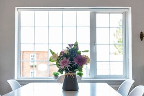 A dining table with a vase of flowers in front of a window with a grid pattern. - Riverside Rest - quirky split-level 3-bed cottage (Ollerton, Nottinghamshire)