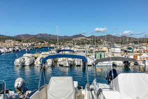 A marina with boats docked, a clear sky, and a town in the background.