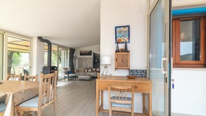 A dining area with a wooden table and chairs, a sofa, and a cabinet with a sign.
