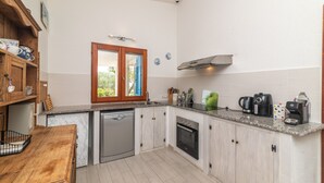 A compact kitchen with a dishwasher, oven, and coffee maker.