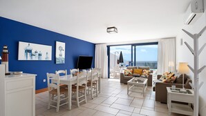 A living room with a dining area, a TV, and a balcony with a view. - Villa 'Malvasia 22' with Sea View, Heated Pool, Balcony, A/C & Wi-Fi (Puerto Calero)