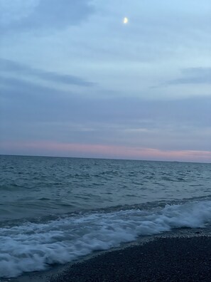 Uma praia com ondas e um céu nublado.