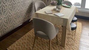 Un coin repas comprenant une table, des chaises, un télescope et un papier peint à motifs.