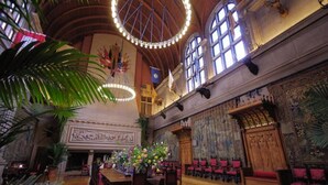Un vaste hall doté d’un plafond haut, de lustres et d’une grande fenêtre.