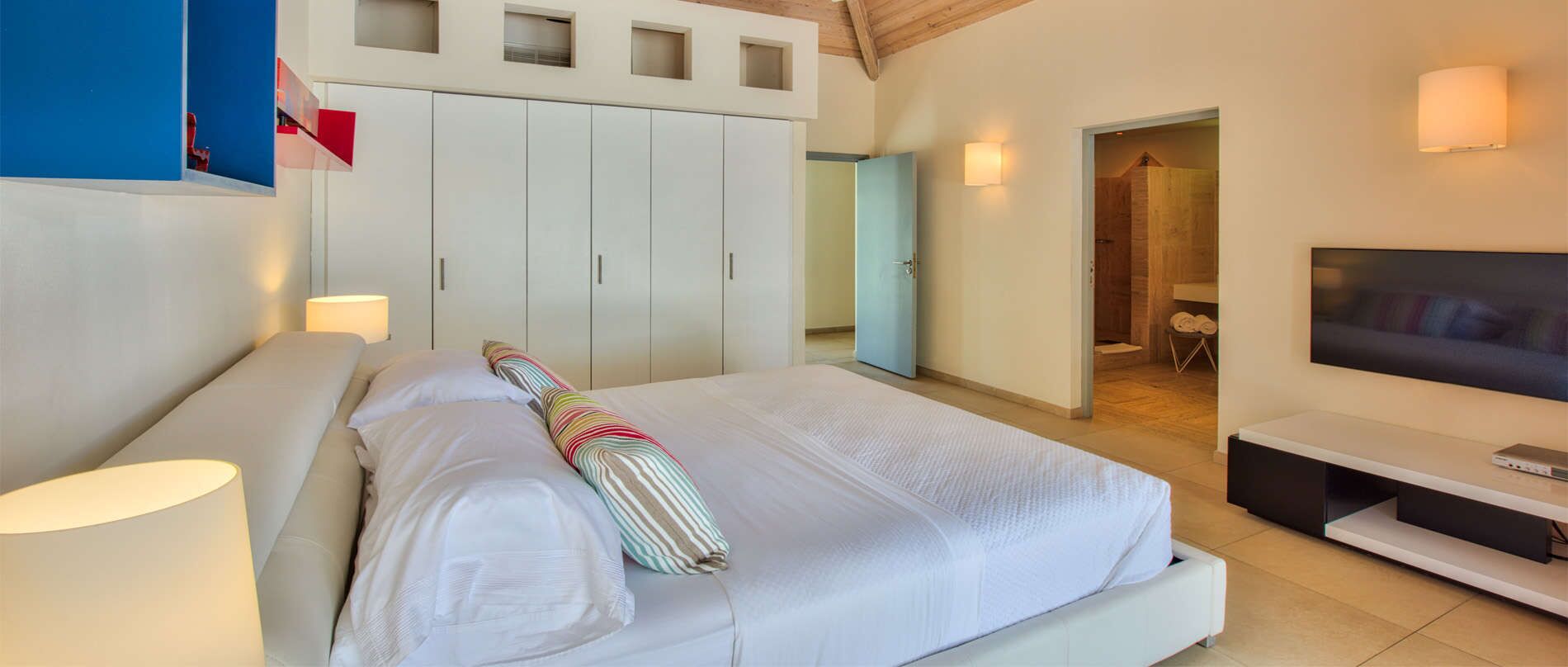 Une chambre à coucher avec un lit, une télévision et une armoire.