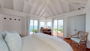 Ein Schlafzimmer mit einem großen Bett, einem Schreibtisch mit Blick und einem Sessel.