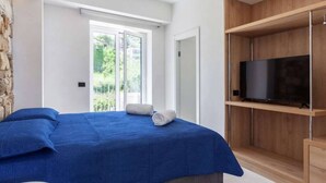 Een slaapkamer met een bed, een televisie en een houten kast.