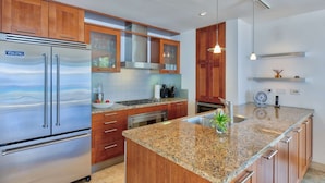 A modern kitchen with wooden cabinets, stainless steel appliances, and granite countertops. - Beautiful Bahari Luxury villa (Simpson Bayv)