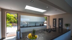 Una cocina moderna con una isla grande, horno integrado y vistas al exterior.