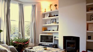 A living room with a fireplace, a television, and a bookshelf.