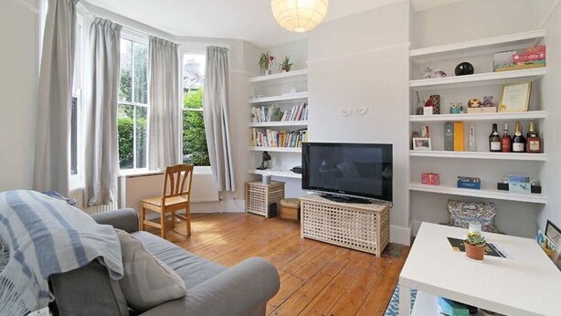 A living room with a sofa, TV, and bookshelves.