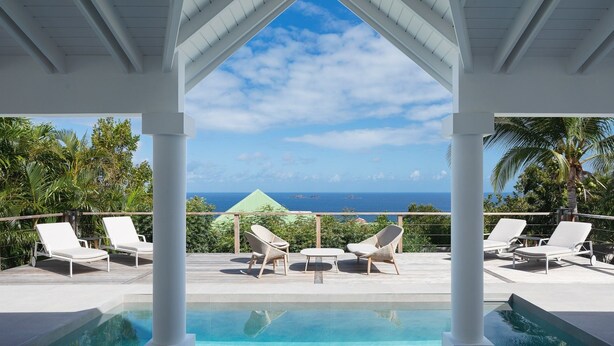 A poolside area with lounge chairs and a view of the ocean. - Bijou (1/2 Rooms) Luxury villa (Flamands)