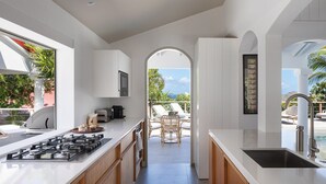 A modern kitchen with a view of a pool and lounge area. - Bijou (1/2 Rooms) Luxury villa (Flamands)