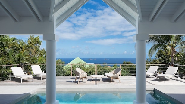 A poolside area with lounge chairs and a view of the ocean. - Beautiful Bijou Luxury villa (Flamands)
