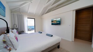 A bedroom with a large bed, a TV mounted on the wall, and a view of the sea through a window. - W View (1/4 Rooms) Luxury villa (Saint Jean)