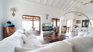 A spacious living area with a large TV, white furniture, and a wooden coffee table. - W View (1/4 Rooms) Luxury villa (Saint Jean)