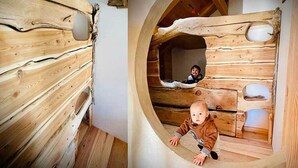 Eine Holzhütte mit rundem Fenster und einem kleinen Innenraum.