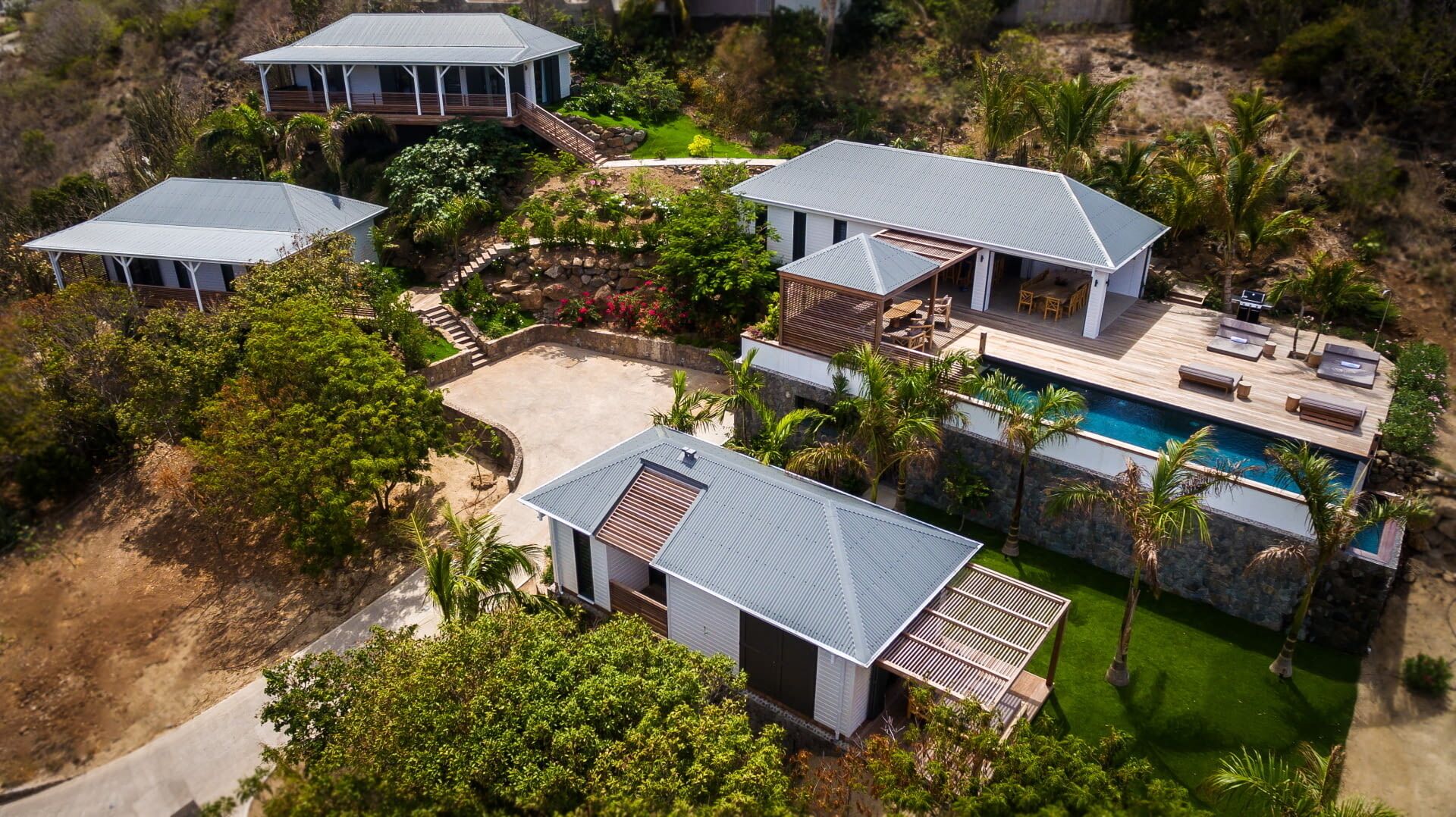 Ein großes, modernes Haus mit mehreren Schlafzimmern, einem Swimmingpool und einem gepflegten Garten.