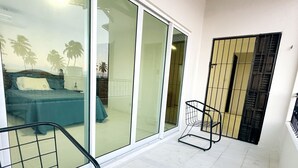 A room with a bed, a chair, and a sliding glass door leading to a balcony. - Beach house with Wi-Fi, pool, and barbecue. (Lucena)