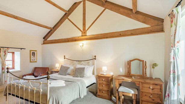 A bedroom with a bed, a wooden desk, a chair, a dresser, and a window with curtains. - The Parlour - UK37517 (Routh, Beverley)
