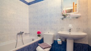 Ein Badezimmer mit Badewanne, Toilette und Waschbecken.