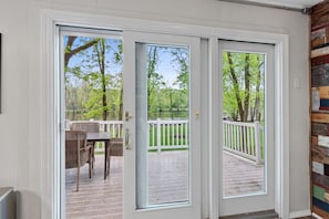 Relax on the outdoor deck with wicker chairs and a table, surrounded by a white picket fence.