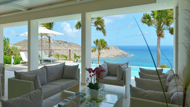 A spacious outdoor seating area with a view of the ocean and mountains. - Enzuma (2/3 Rooms) Luxury villa (Toiny)