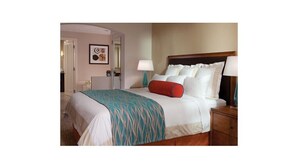 A hotel room with a bed, bedside tables, a lamp, and a door. - Marriott's Desert Springs Villas II Resort (Palm Desert)