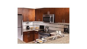 A kitchen with dark wooden cabinets, stainless steel appliances, and a granite countertop. - Marriott's Desert Springs Villas II Resort (Palm Desert)