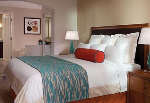 A hotel room with a bed, bedside tables, a lamp, and a door. - Marriott's Desert Springs Villas II Resort (Palm Desert)