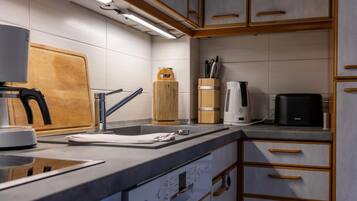 Eine moderne Küche mit integriertem Spülbecken, einer Kaffeemaschine und Holzschränken.